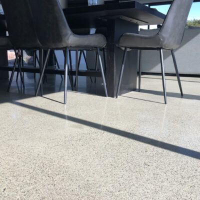 chairs placed on a polished concrete floor in a residential space